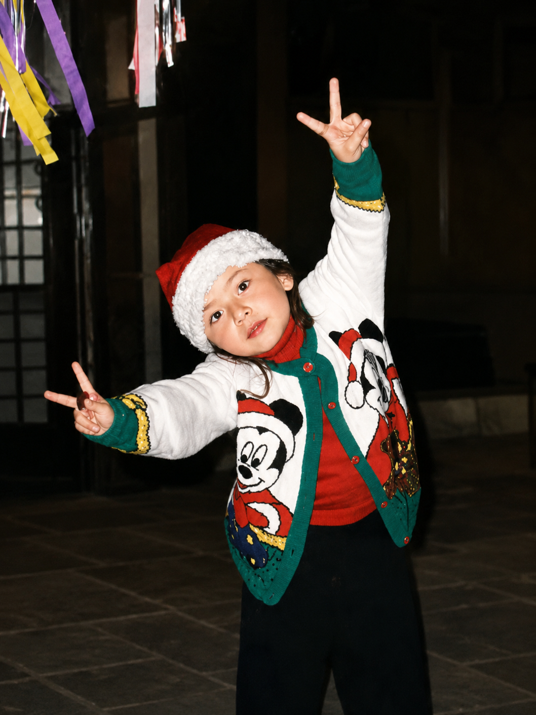 Diana de niña celebrando con una pose llena de energía